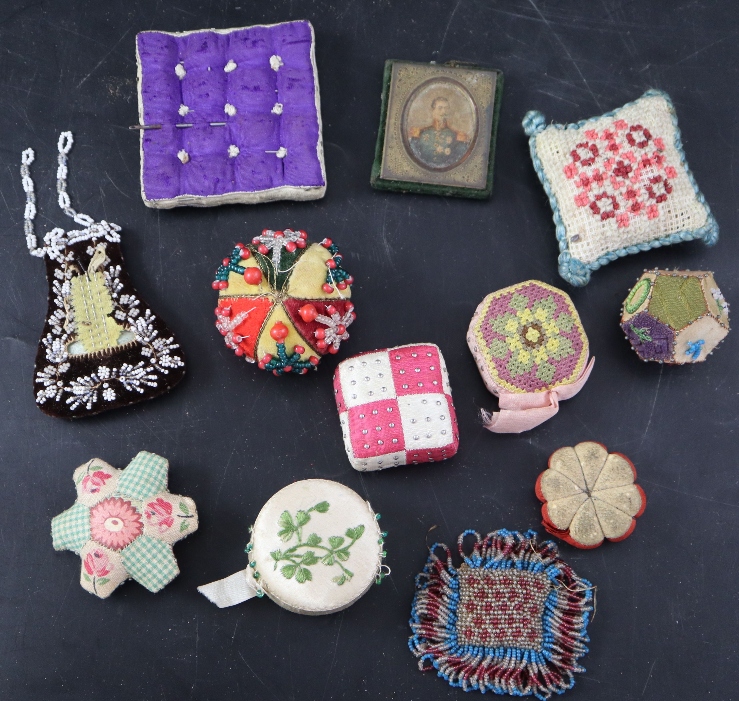 Twelve assorted 19th century fabric pin cushions